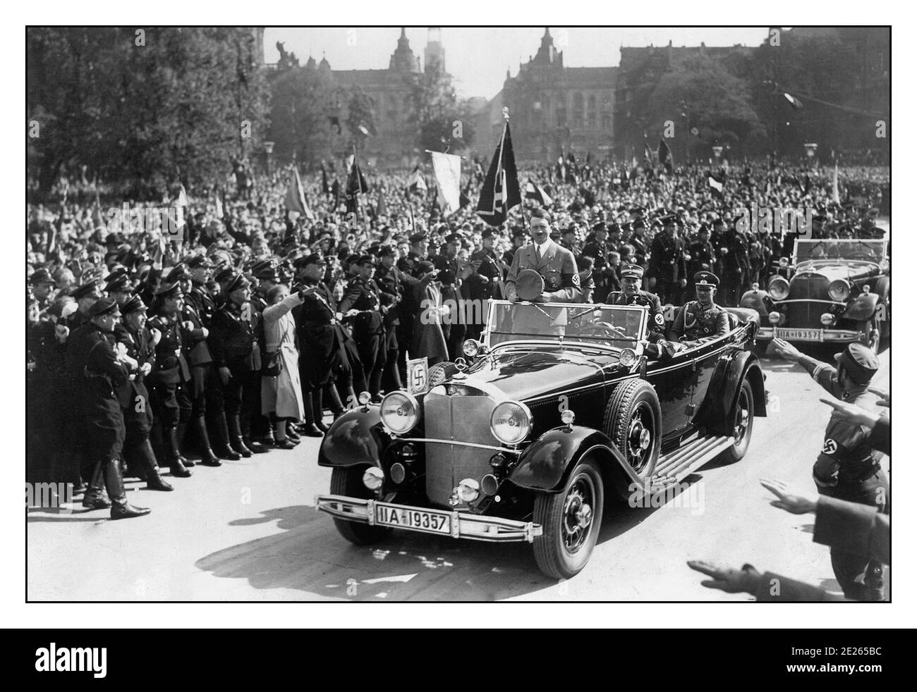Vintage Adolf Hitler Nazi Führer Deutsche Führer Parade mit Autokolonne In offenen Mercedes-Motorwagen mit ekstatischen Massen winken Hakenkreuz Fahnen und grüssen Heil Hitler zu ihm und seiner Autokolonne Parade 1940er Jahre Deutschland Stockfoto