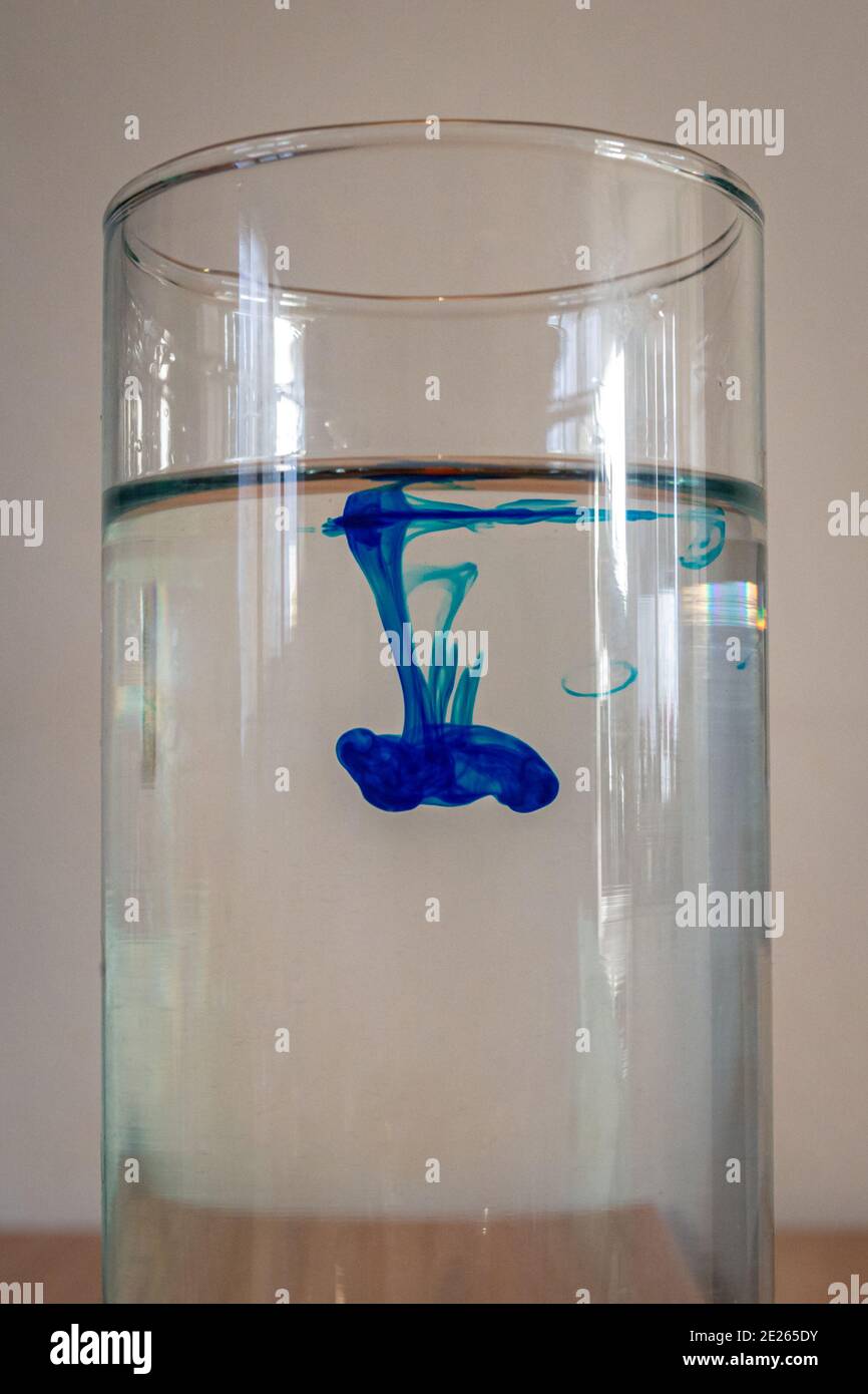 Fluiddynamik-Experiment, wo ein Tropfen blauer Farbstoff ist In Wasser geben Stockfoto