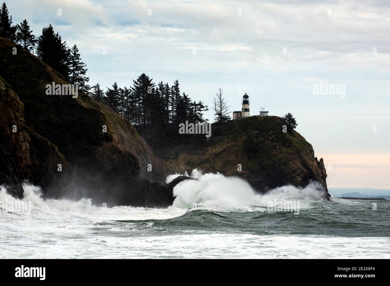WA19101-00...WASHINGTON - Wellen schlagen in Klippen am Columbia River Abfluss unter Cape Disappointment Lighthouse in Cape Disappointment State P Stockfoto