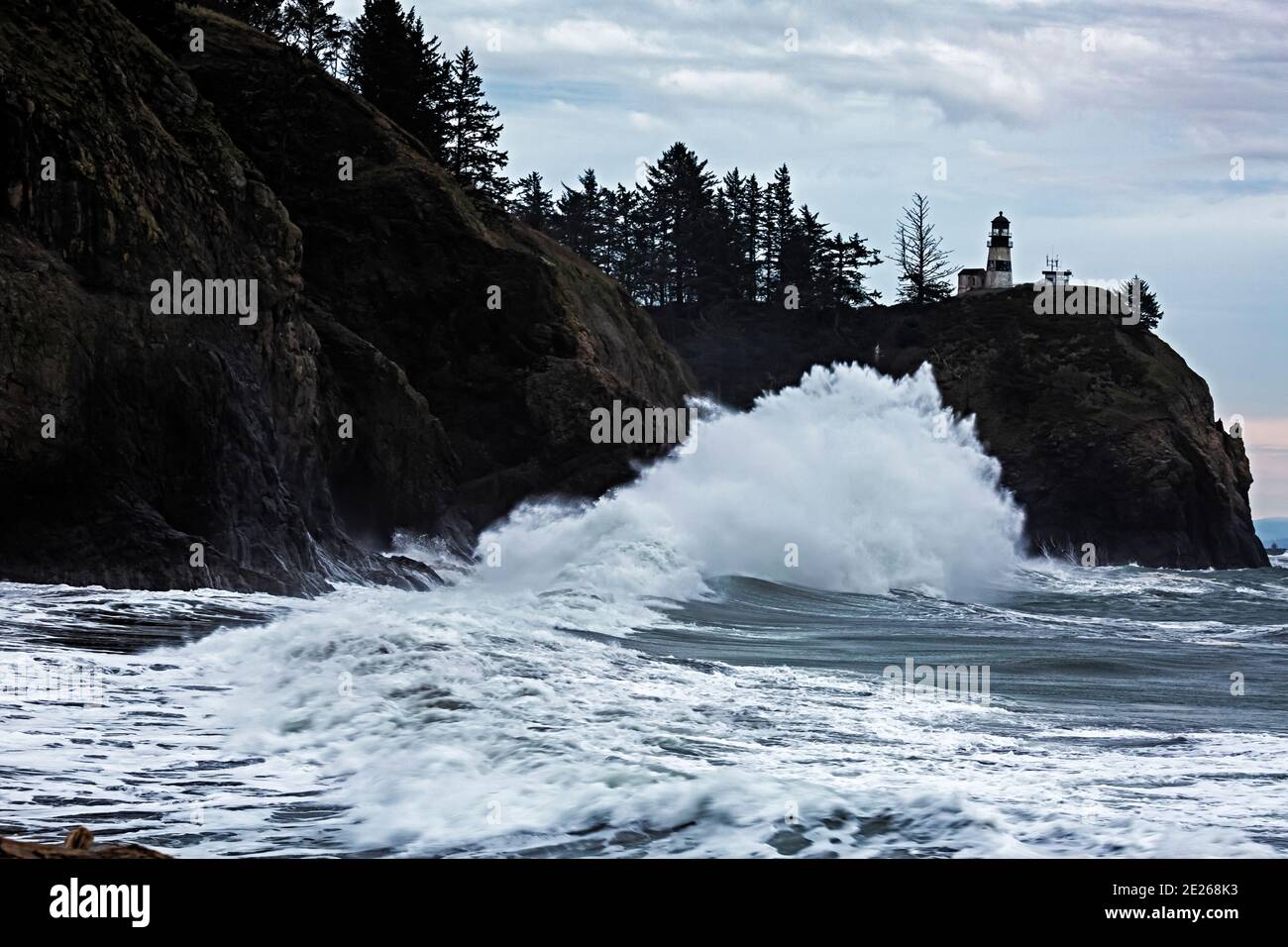 WA19104-00...WASHINGTON - Wellen schlagen in Klippen am Columbia River Abfluss unter Cape Disappointment Lighthouse in Cape Disappointment State P Stockfoto