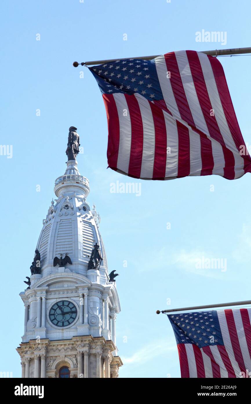 Amerikanische Flaggen fliegen von Flagstaffs in der Nähe des Turms der Philadelphia City Hall in Philadelphia, USA. Stockfoto