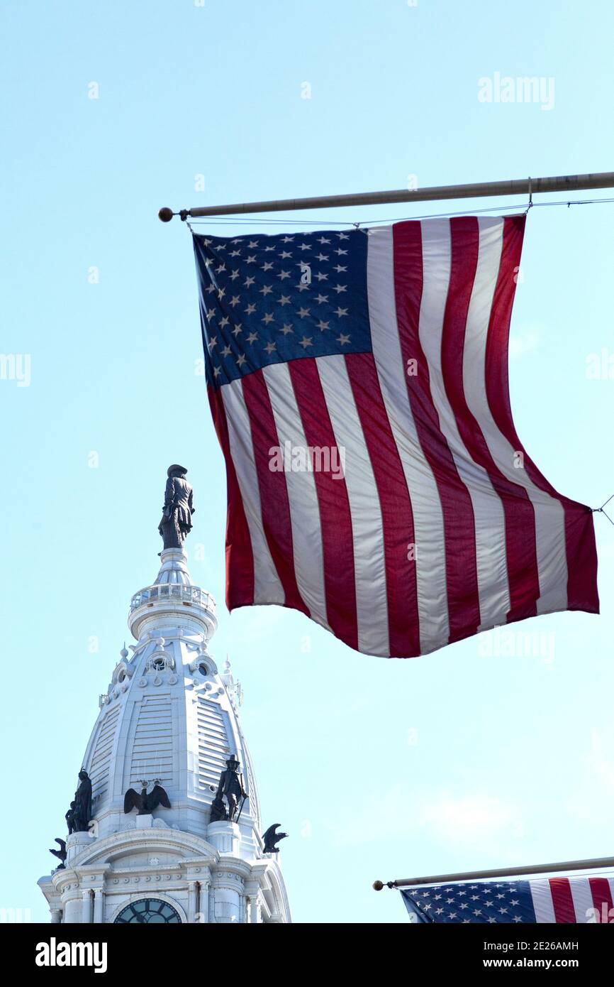 Amerikanische Flaggen fliegen von Flagstaffs in der Nähe des Turms der Philadelphia City Hall in Philadelphia, USA. Stockfoto