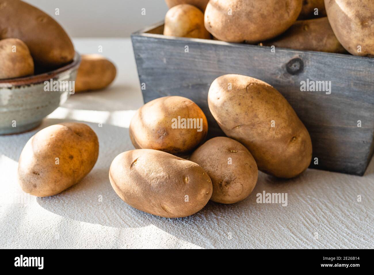 Rohe Bio-Kartoffeln aus nächster Nähe auf dem Küchentisch, Morgensonne vom Fenster Stockfoto