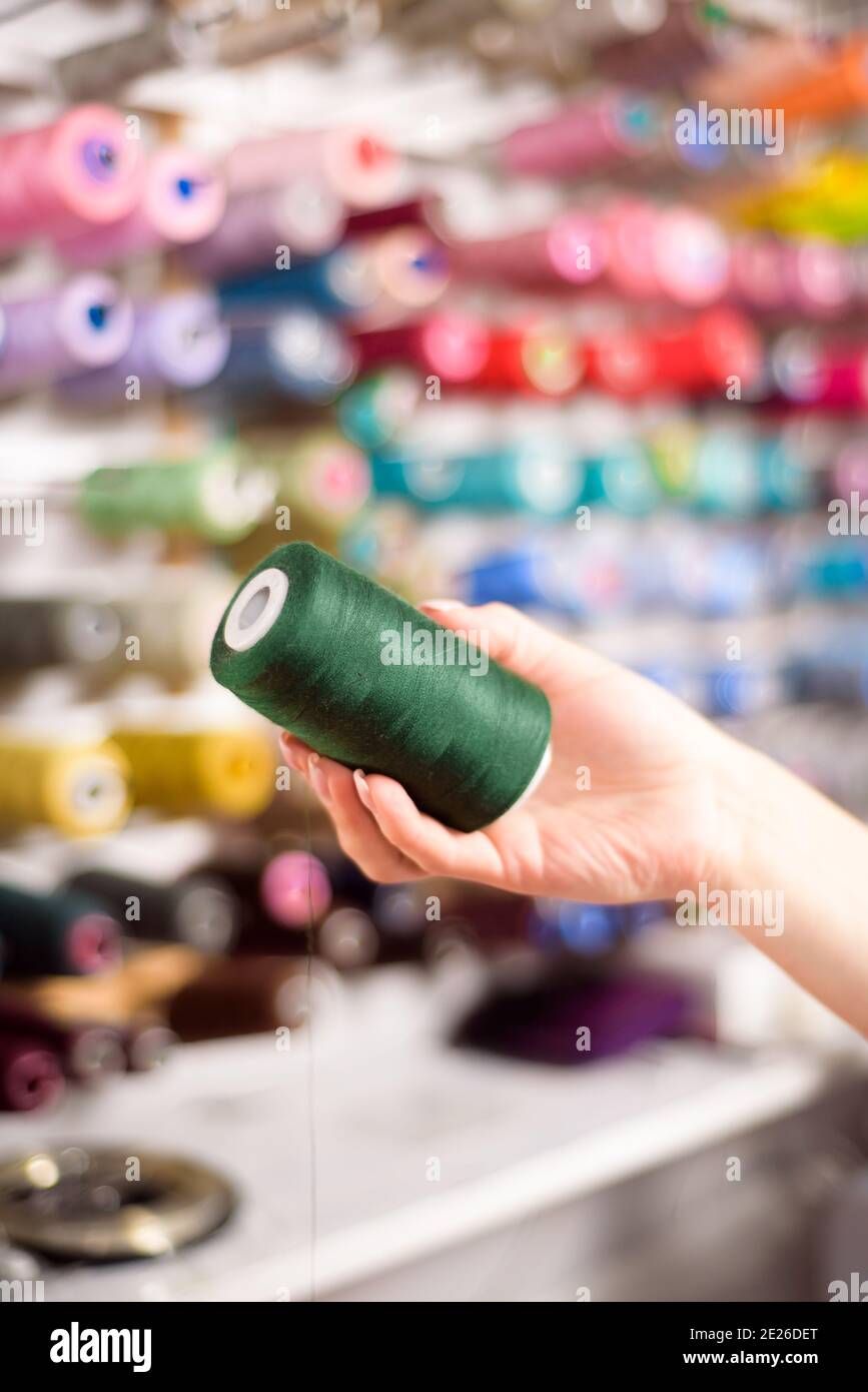 Bunte Zapfen und Garnrollen in einem Atelier.Schneiderei, Bekleidungsindustrie, Designer-Workshop-Konzept. Stockfoto