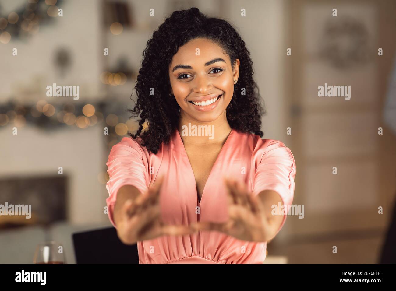 afroamerikanische Frau im Kleid, die Hände zur Kamera reicht Stockfoto