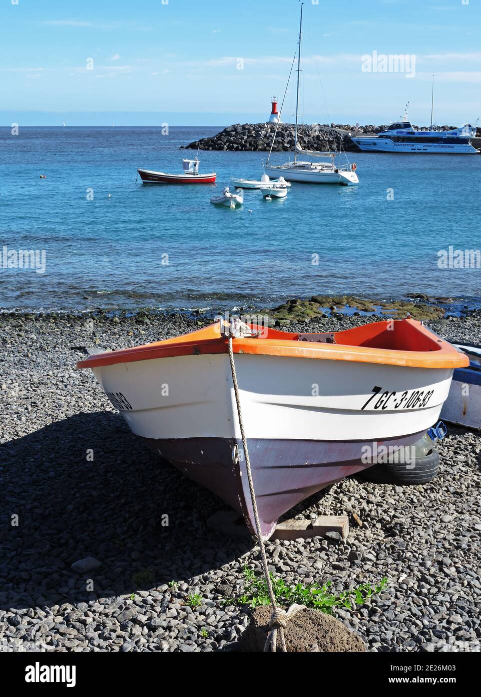 Ein kleines Boot an der Küste von Playa Blanca, Lanzarote, mit blauem Himmel und Wasser auf der Rückseite, bietet ein nautisches Urlaubsthema Stockfoto