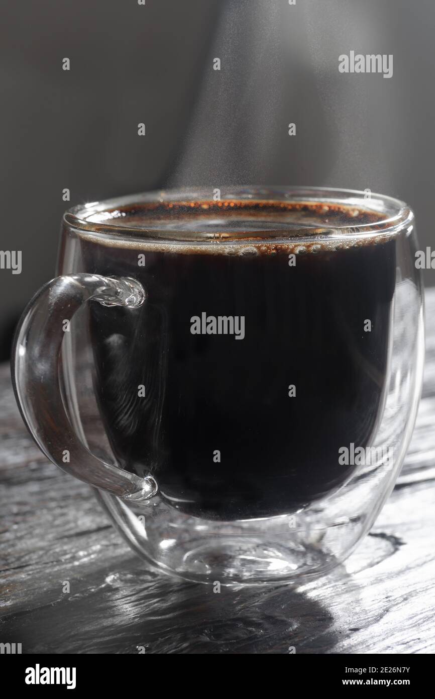 Heißer schwarzer Kaffee auf dem alten Holztisch Stockfoto