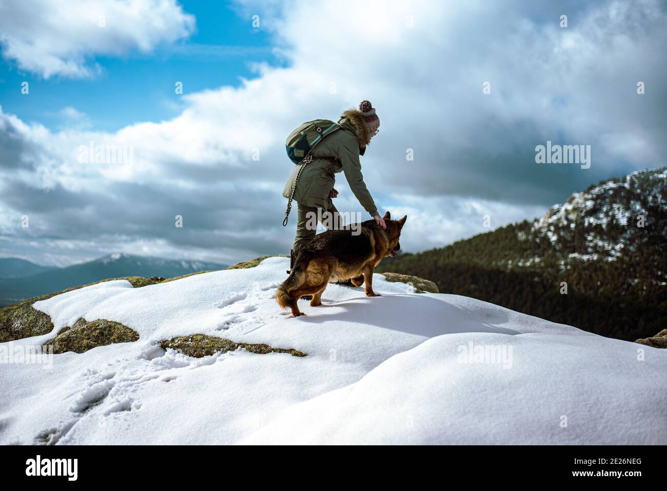 Junges Mädchen führen einen Hund durch den Schnee in der Berge im Winter Stockfoto