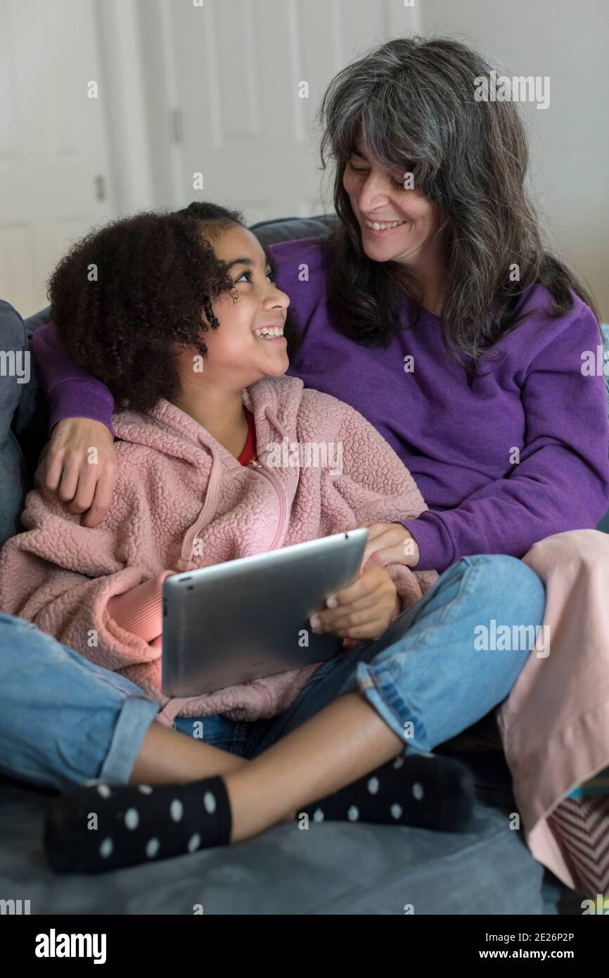 Kaukasische Mutter und bi-rassische Pre-Teen-Tochter lächeln sich gegenseitig an Stockfoto