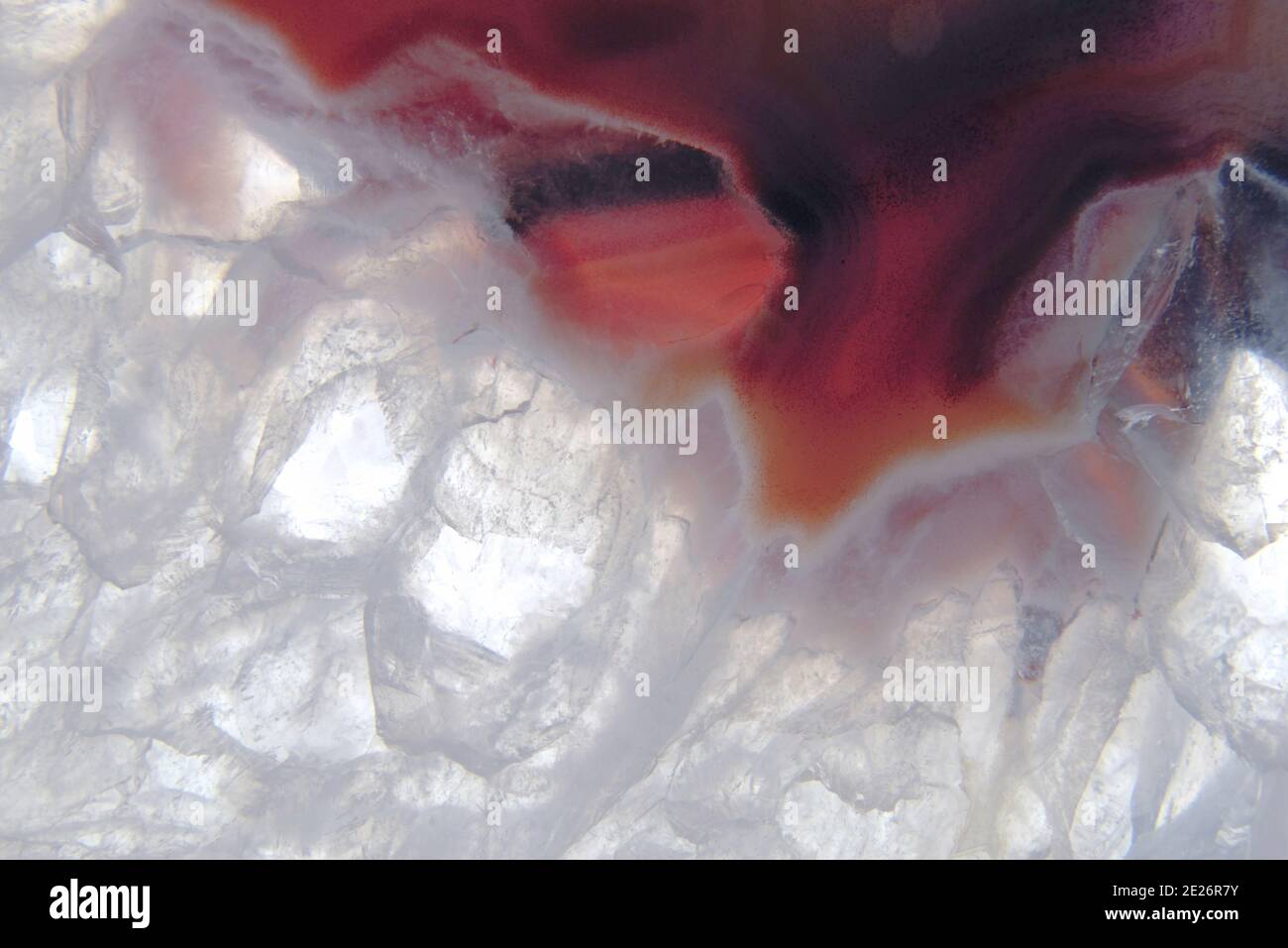 Extreme Nahaufnahme Makrofotografie der Muster, Textur und Kristallisation eines Achates. Diese ist hauptsächlich rot und weiß gefärbt. Stockfoto