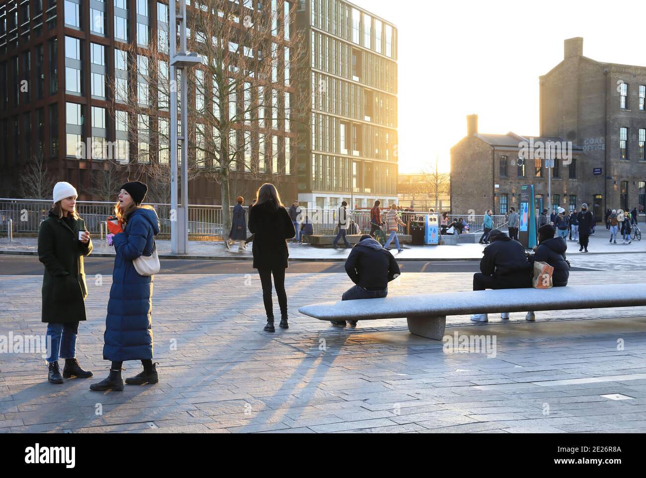 Soziale Distanzierung bei der Pandemie Covid-19 in der Wintersonne auf dem Granary Square bei Kings Cross, Nord-London, Großbritannien Stockfoto