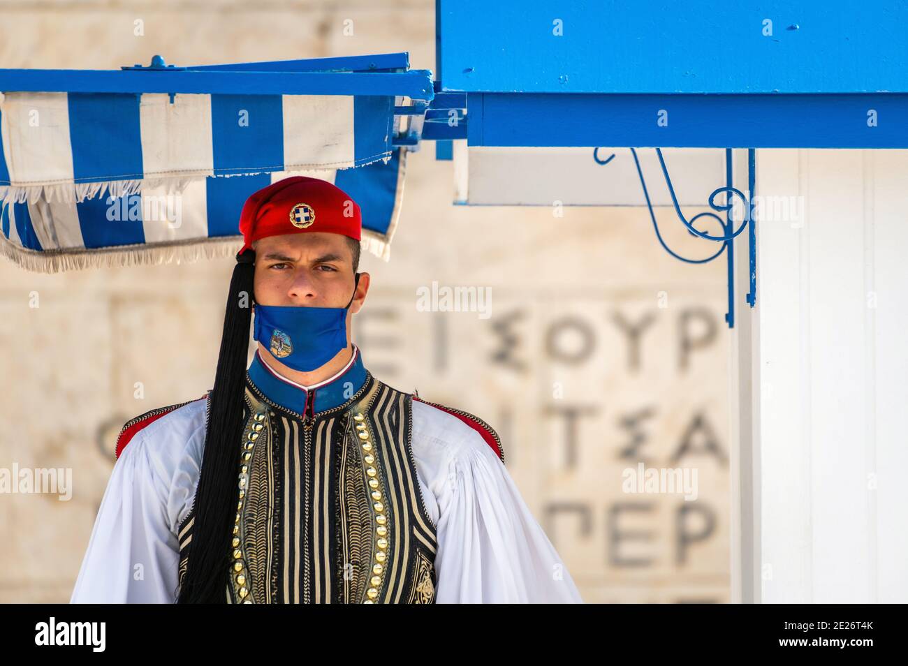 Soldat der griechischen Präsidentengarde (Evzone) mit Gesichtsmask vor dem Grab des unbekannten Soldaten in Athen, Griechenland Stockfoto