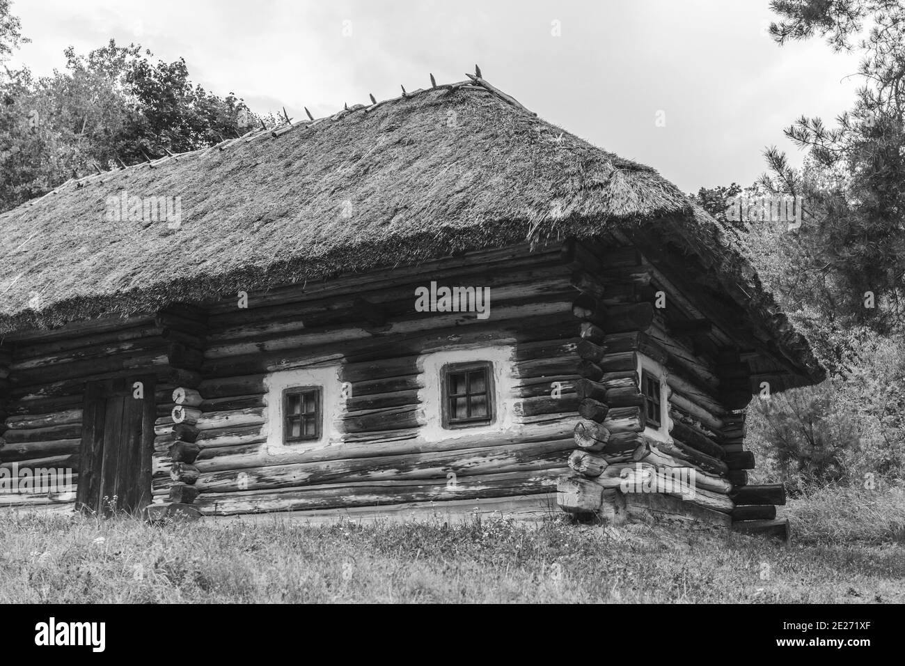 Schwarz Weiß Foto von alten ländlichen Architektur. Holzhaus mit Strohdach, Blockhaus. Stockfoto