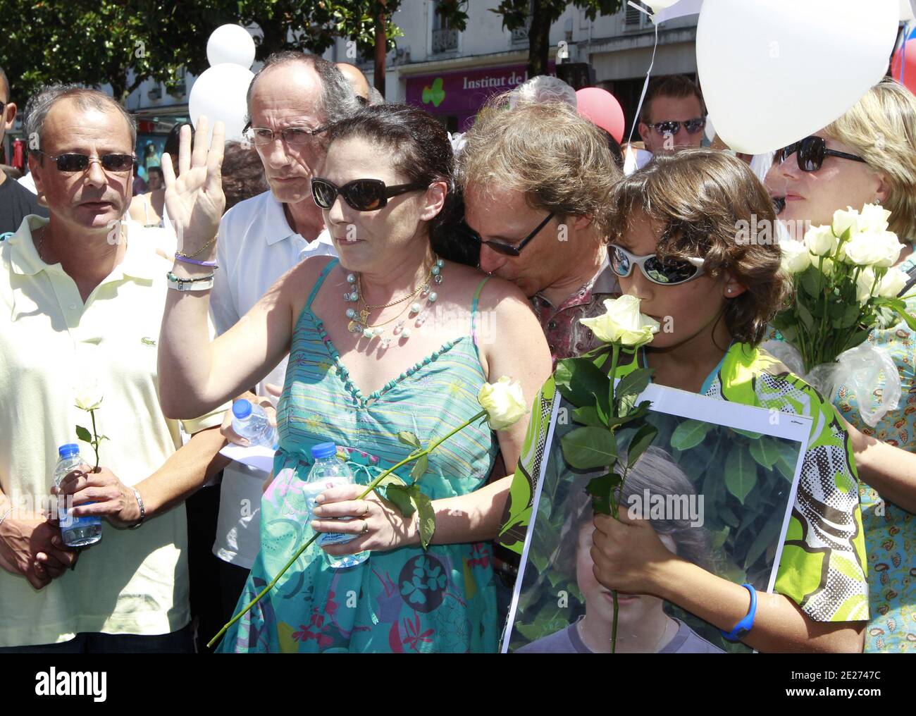 Des membres de la famille d'Alexandre Junca dont sa mère Valérie Lance(bleu) , son beau-père Daniel Lance (Rose), et son pere (jaune) Premier mari de Valerie, participent, le 02 juillet 2011 à Pau, aux côtés de 4.500 personnes, à une marche Blanche en Hommage à l'adolescent disparu le 4 juin à Pau et dont le décès est confirmé après la découverte de son fémur et d'une de ses cusses dans une Rivière. Foto von Patrick Bernard/ABACAPRESS.COM Stockfoto