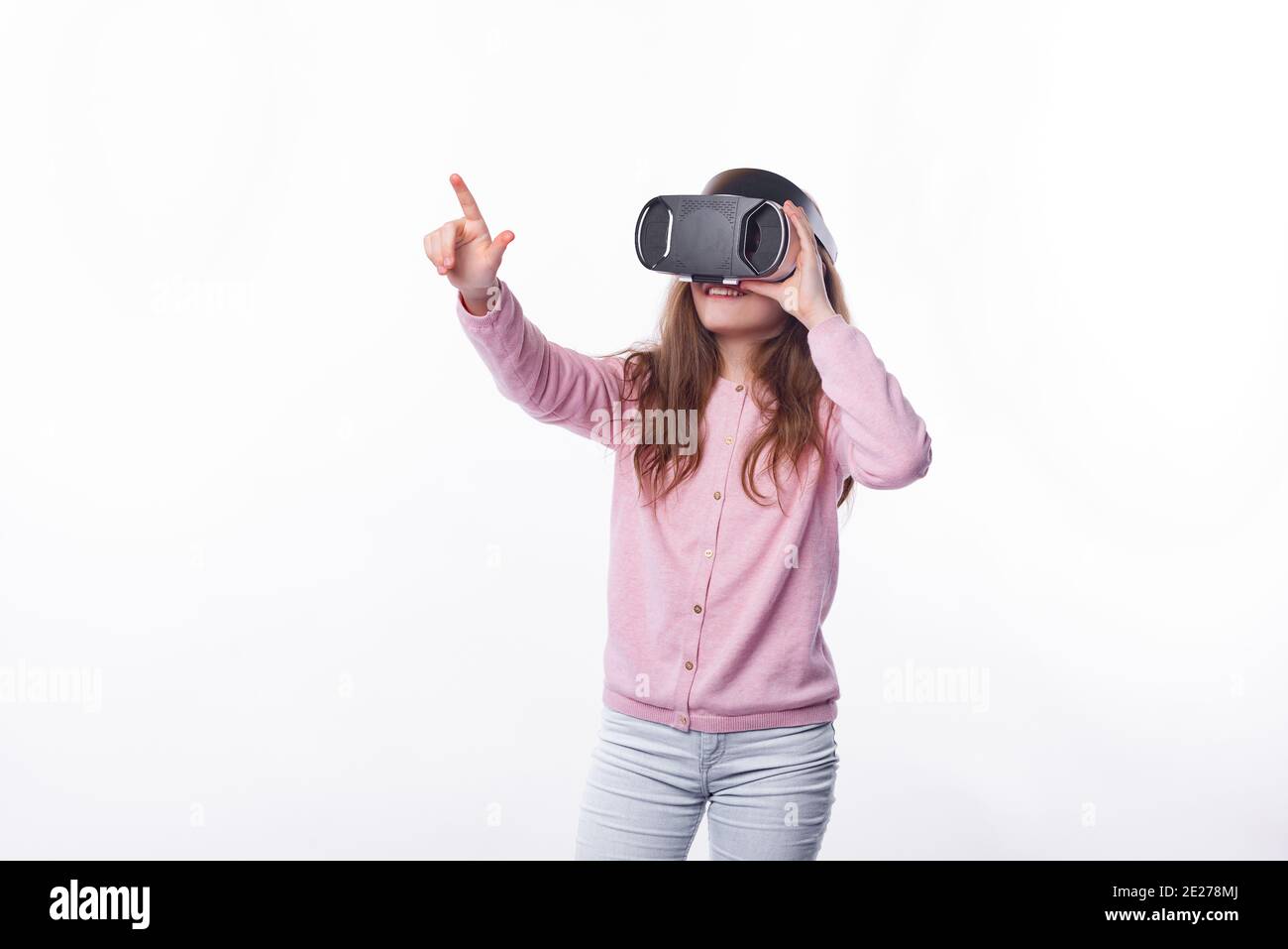 Foto von jungen Mädchen trägt VR-Brille und zeigt auf etwas. Stockfoto