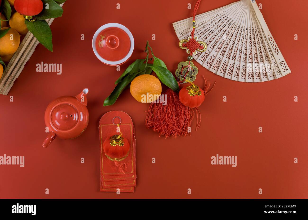 Happy Lunar Chinese New Year Feiern mit Zeremonie Tee-Set, traditionelle Laterne roten Umschläge Paket Ang Pau auf Mandarinen Orangen einen roten Hintergrund Stockfoto