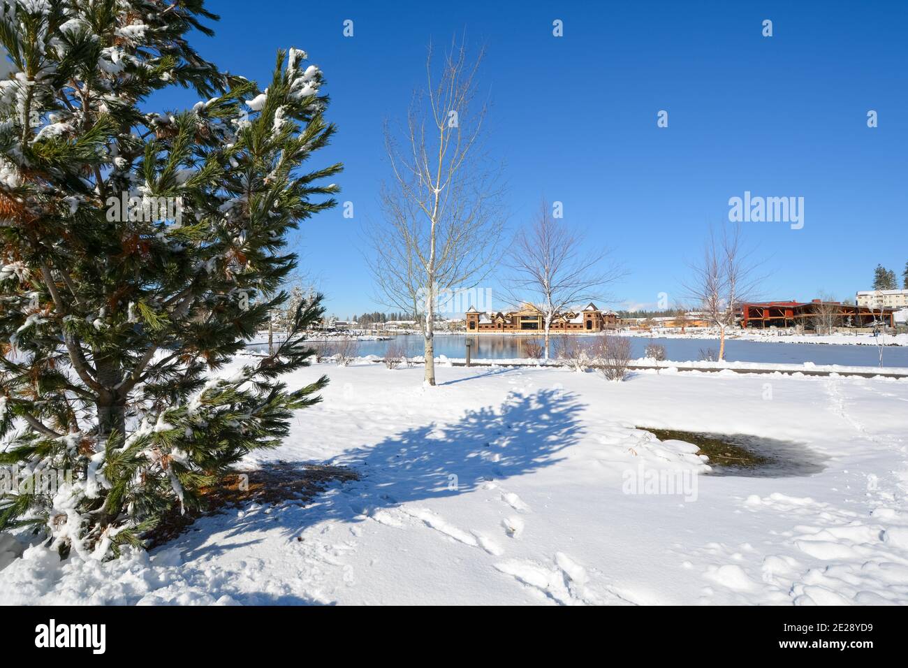 Der Teich oder See am Riverstone gemischt Gebrauch Eigentumswohnung und Einzelhandel Entwicklung mit Schnee im Winter in der Innenstadt von Coeur d'Alene, Idaho, USA. Stockfoto