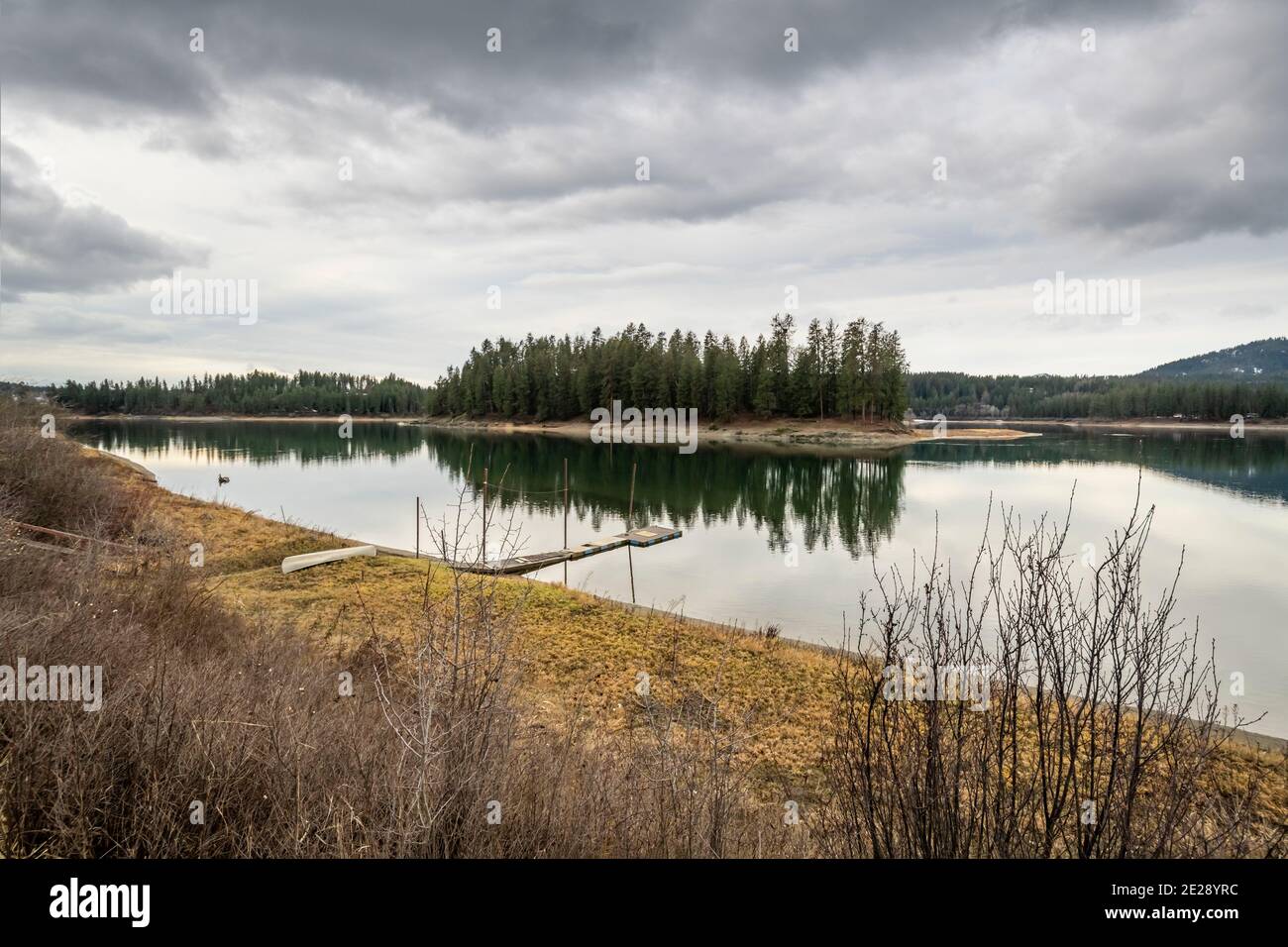 Eine kleine Bootsanlegestelle in der Nähe von Kelly Island, einer kleinen Insel im Priest River in der Nähe der Stadt Newport, Washington, USA, bei bewölktem Himmel. Stockfoto