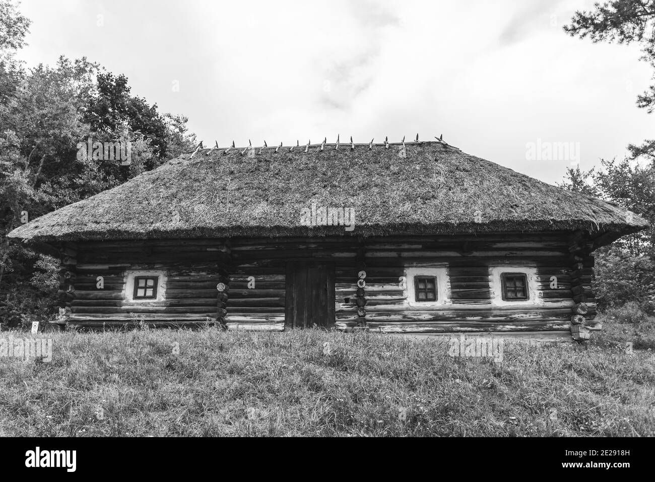 Schwarz Weiß Foto von alten ländlichen Architektur. Holzhaus mit Strohdach, Blockhaus. Stockfoto