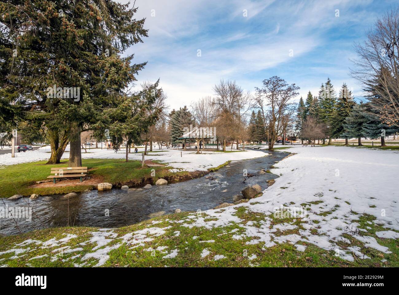 Ein kleiner Bach fließt durch den kleinen öffentlichen Park mit Schnee im Winter bei Rathdrum, Idaho USA. Stockfoto