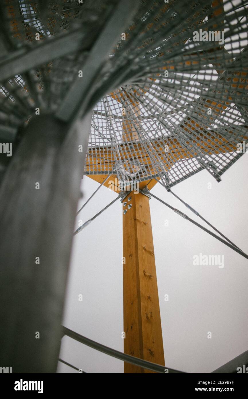 Low-Angle-Aufnahme einer kreisförmigen Stahltreppe mit Netz Eine Holzbaustelle Stockfoto