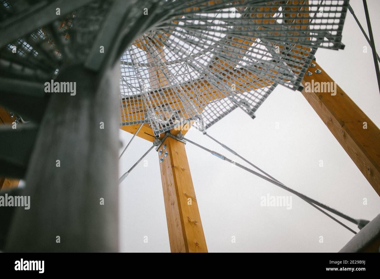 Low-Angle-Aufnahme einer kreisförmigen Stahltreppe mit Netz Eine Holzbaustelle Stockfoto