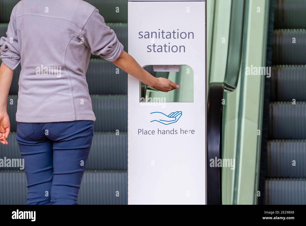 Nahaufnahme einer Frau, die ihre Hände an der Sanitäranlagen desinfiziert Stockfoto