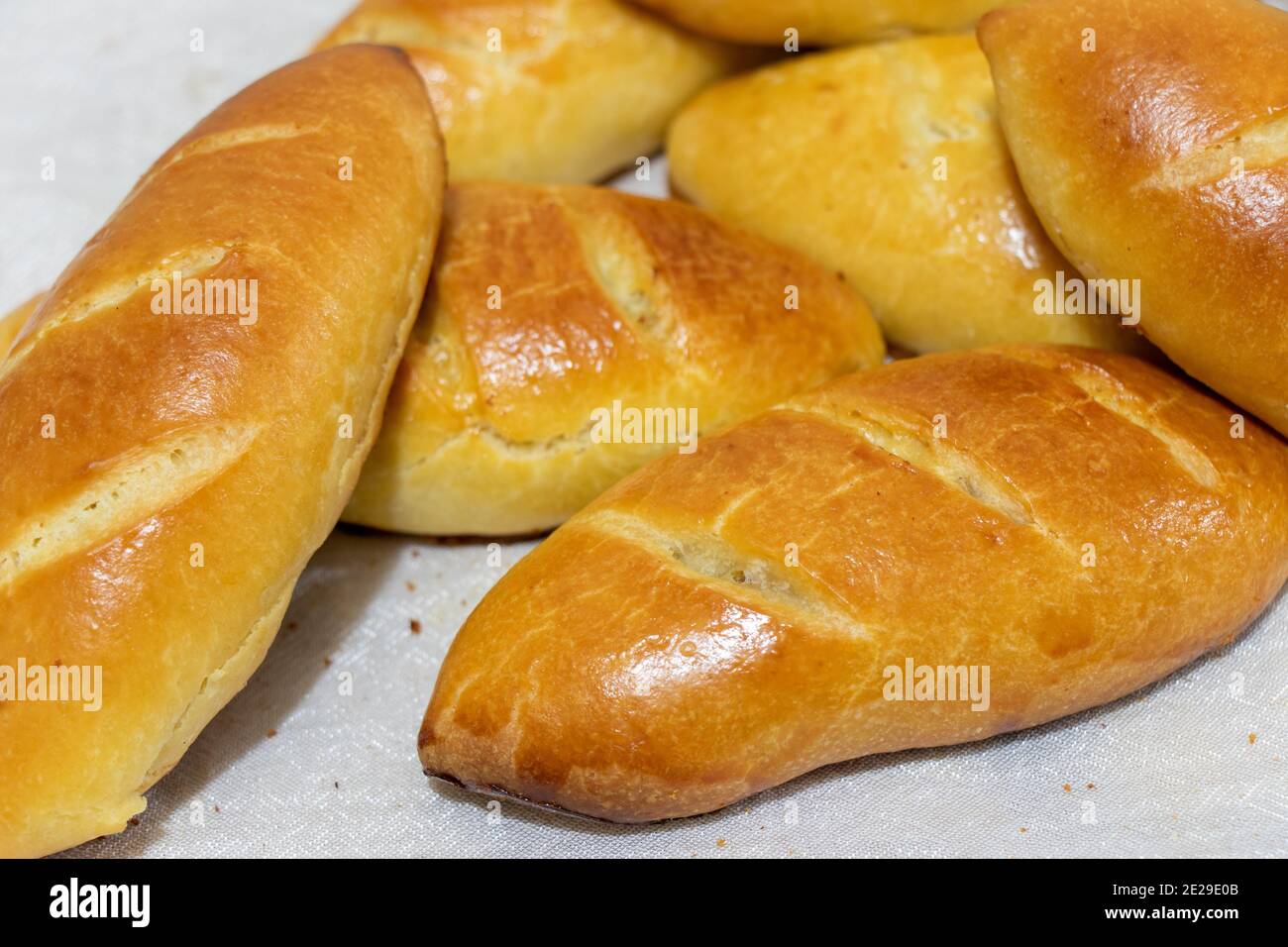 Frisch gebackene Kuchen. Russische Kuchen - Piroschki mit Kartoffeln. Pirozhki. Hintergrund für das Essen Stockfoto