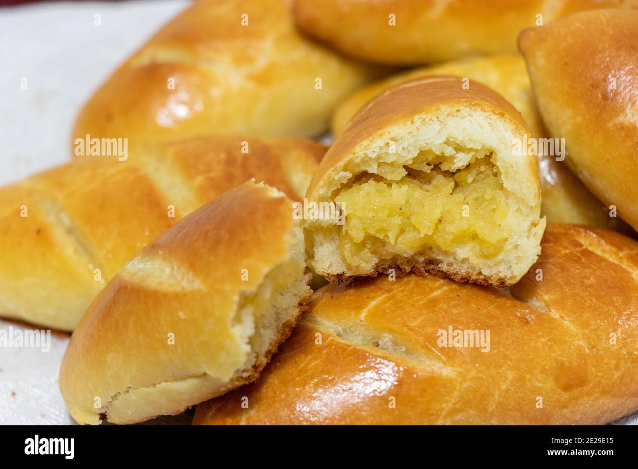 Frisch gebackene Kuchen. Russische Kuchen - Piroschki mit Kartoffeln. Pirozhki. Hintergrund für das Essen Stockfoto