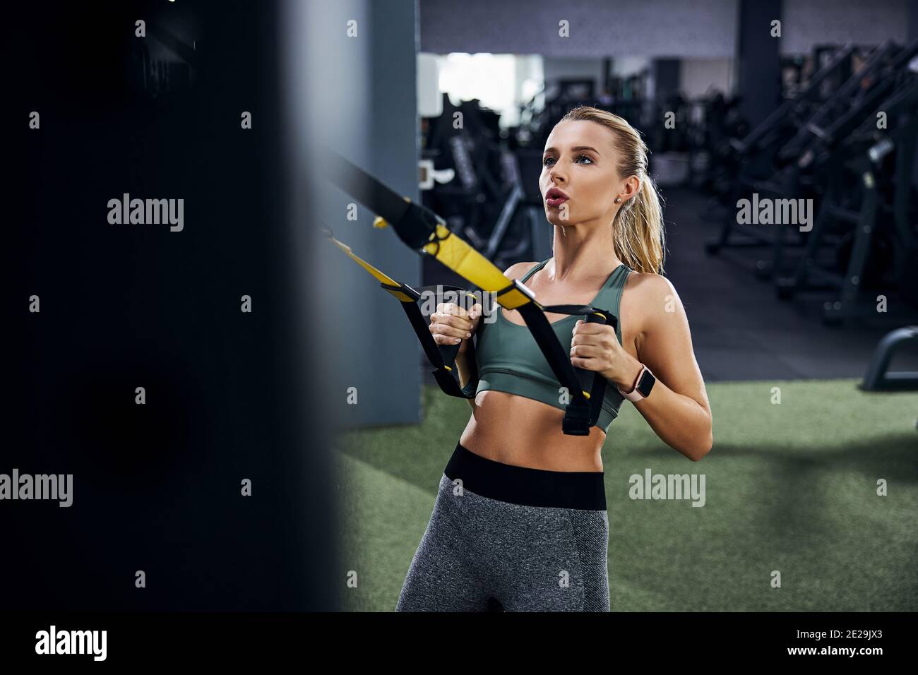 Die Sportlerin nimmt sich auf und greift dabei an den Trägern Stockfoto