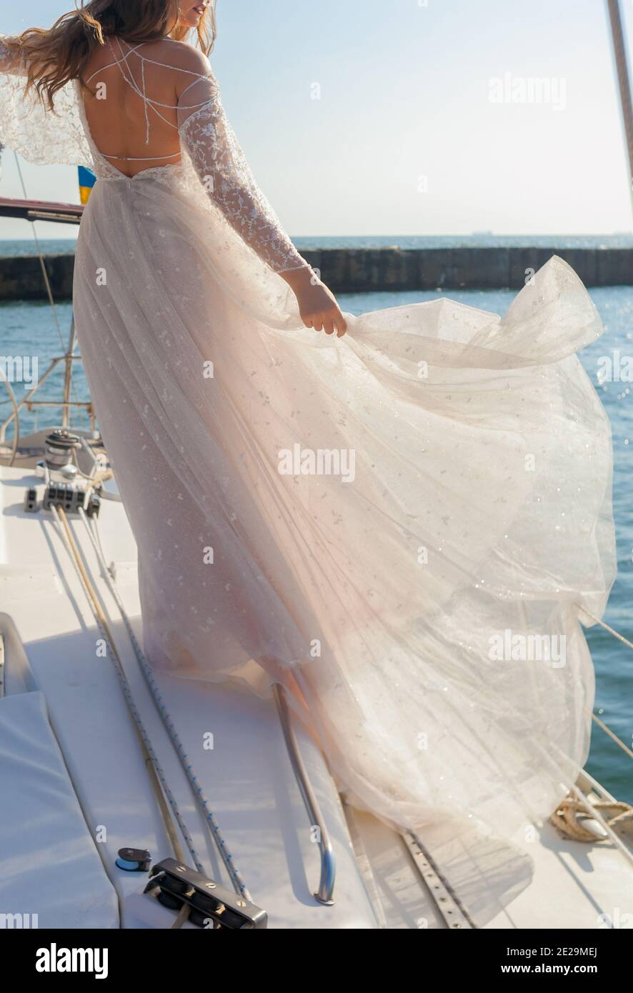 Beautiful Bride hält das Kleid auf dem Deck des yacht Stockfoto