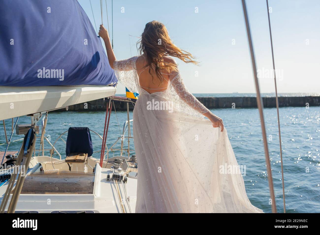 Braut hält das Kleid auf dem Deck der Yacht Stockfoto