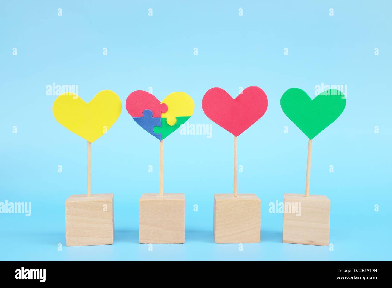 Konzept des Kindes mit Autismus-Spektrum-Störung Gleichheit, Vielfalt und Eingliederung in die Gesellschaft. Puzzle Herz Form unter bunten Gruppe. Stockfoto