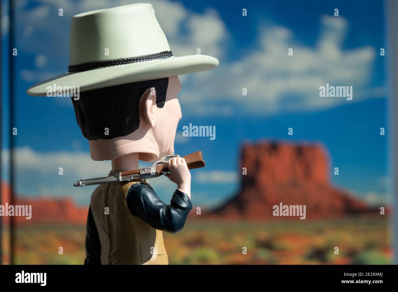 Figur eines amerikanischen Cowboys, der in den Hintergrund starrte Mit einem Buchcover über Monument Valley Stockfoto