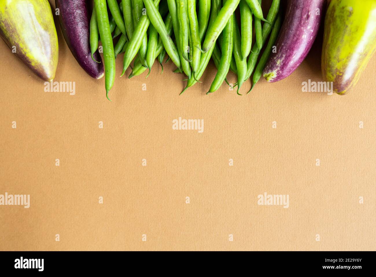 Grüne Bohnen Paprika und Mini Auberginen auf braunem Hintergrund Kopie Space.Harvest Bio gesunde Lebensmittel Stockfoto