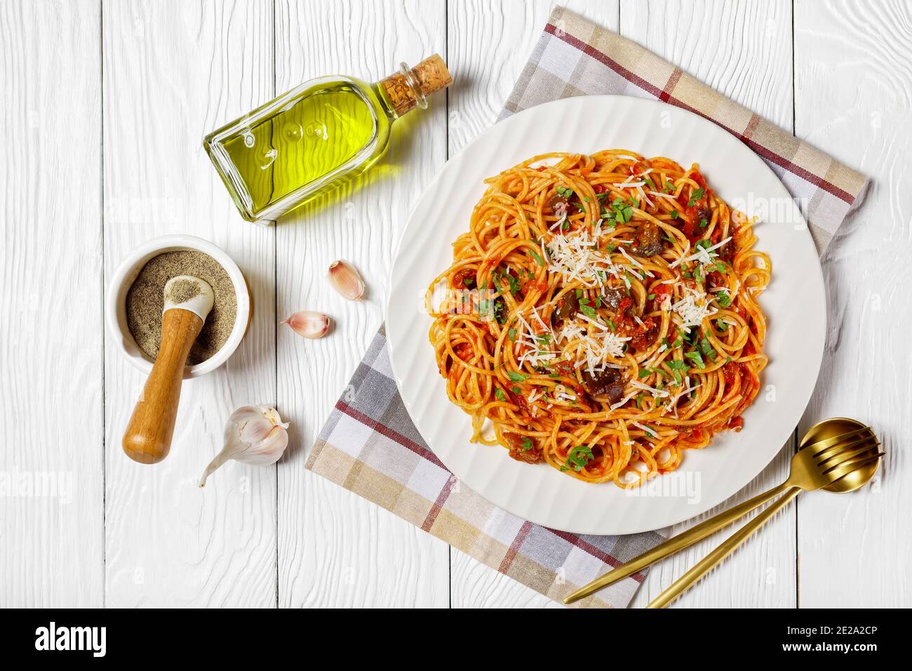 Pasta Spaghetti alla norma auf einem weißen Teller auf einem weißen Holztisch mit Zutaten, italienische Küche, horizontale Ansicht von oben, flache Laie Stockfoto