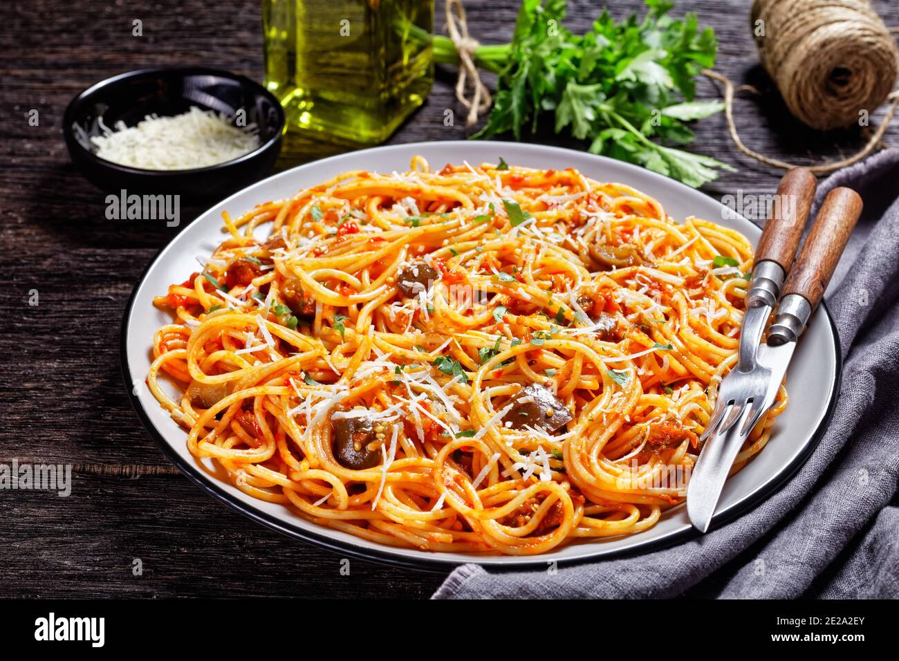 Spaghetti alla norma, sizilianische Pasta-Gericht aus sautierten Auberginen mit Tomatensauce geworfen und gekrönt mit zerfetzten Parmesan serviert auf einem Teller, italienische Cu Stockfoto