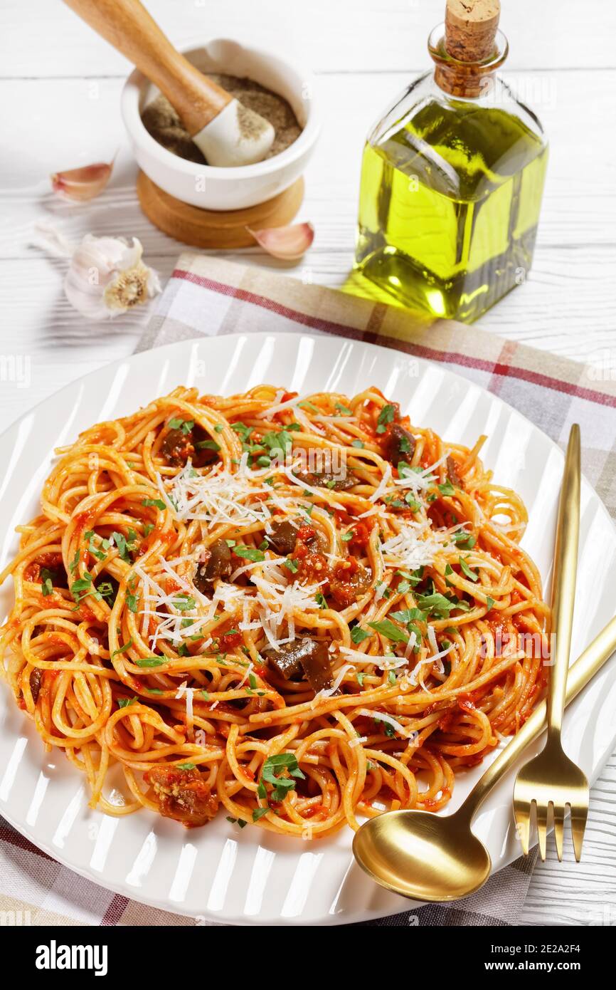 Traditionelle sizilianische Pasta Gericht aus sautierten Auberginen mit Tomatensauce geworfen und gekrönt mit zerfetzten Parmesan serviert auf einem weißen Teller, italienische Küche Stockfoto