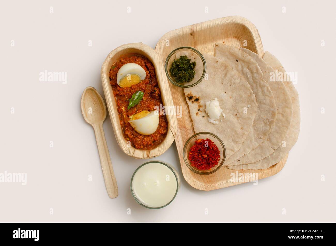 Mittagessen, Thali, Mittagessen auf einer Platte serviert, Thecha, Green Chili Crushed, Knoblauch Chutney, Egg Masala, Cut Boiled Egg, Butter Milk, Top Angle View, Studi Stockfoto