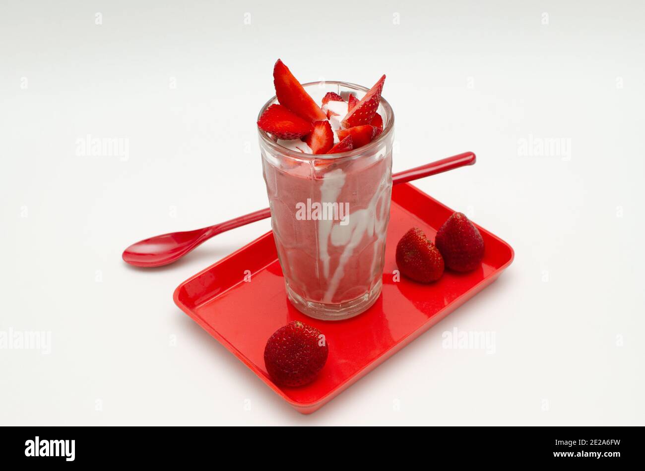 Frische Erdbeermilch mit Sahne schütteln und Erdbeeren schneiden. Draufsicht, Studioaufnahme Stockfoto