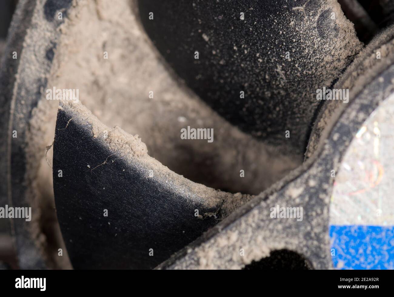 Teil eines verschmutzten CPU-Lüfters. Geringe Schärfentiefe, Fokus auf Rotorblatt. Schmutz darunter verstopft den Kühlkörper vollständig, befindet sich aber nicht in der Schärfentiefe. Stockfoto