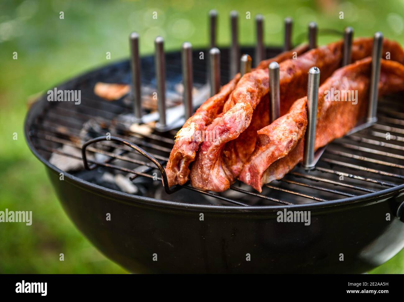 Baby zurück Spare Ribs Braten auf BBQ Grill Kugelgrill. Hausgemachte Schweinerippchen auf einem Grill mit geringe und langsame Methode. Grillen draußen in der Natur bei Fami Stockfoto