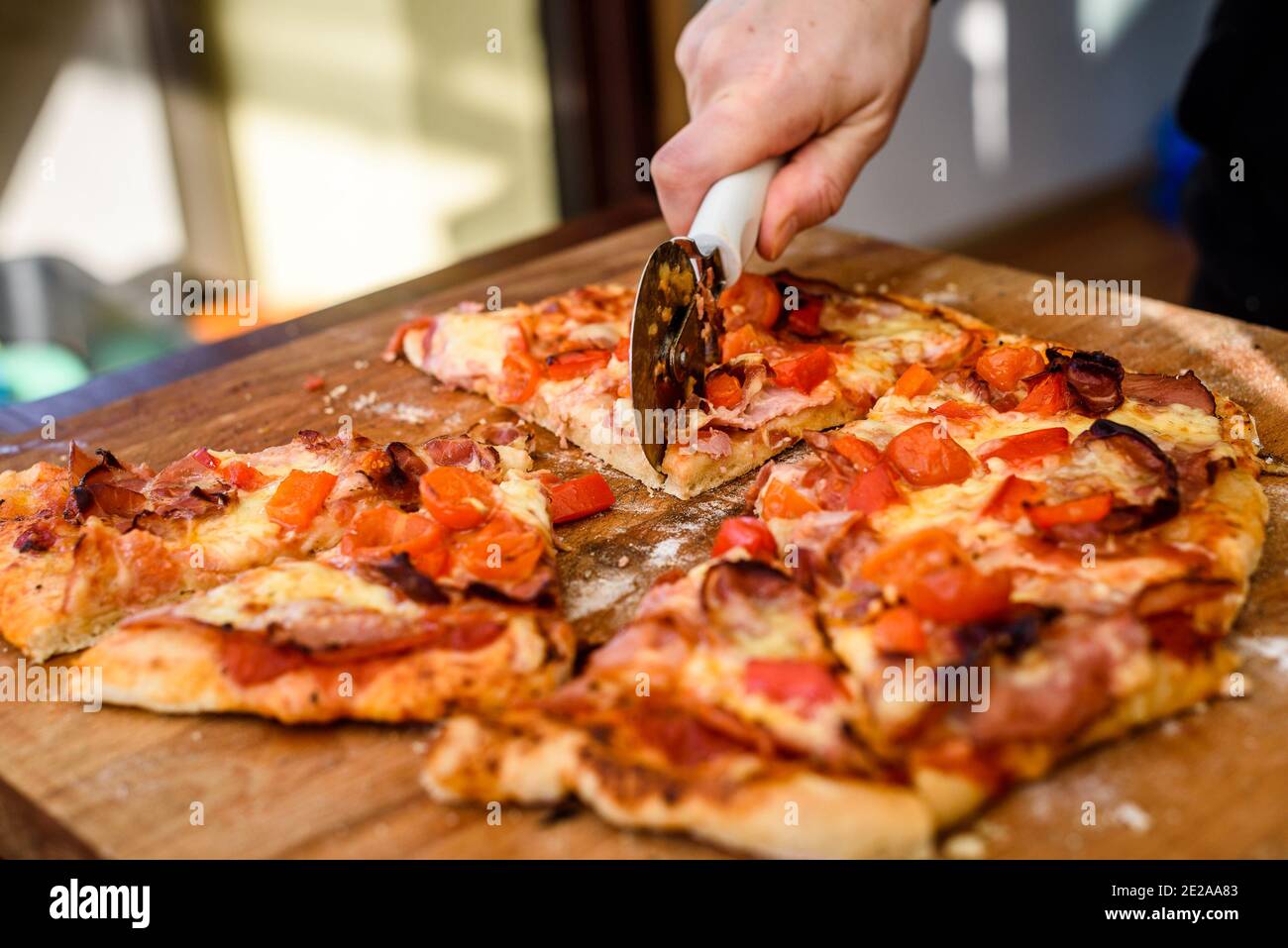Herstellung von hausgemachten italienischen Pizza im Kamin Backstein Ofen. Herstellung von traditionellen Pizza in Stein gemauerten Kamin mit Feuer Holz und Kohlen. Schneiden von Finis Stockfoto