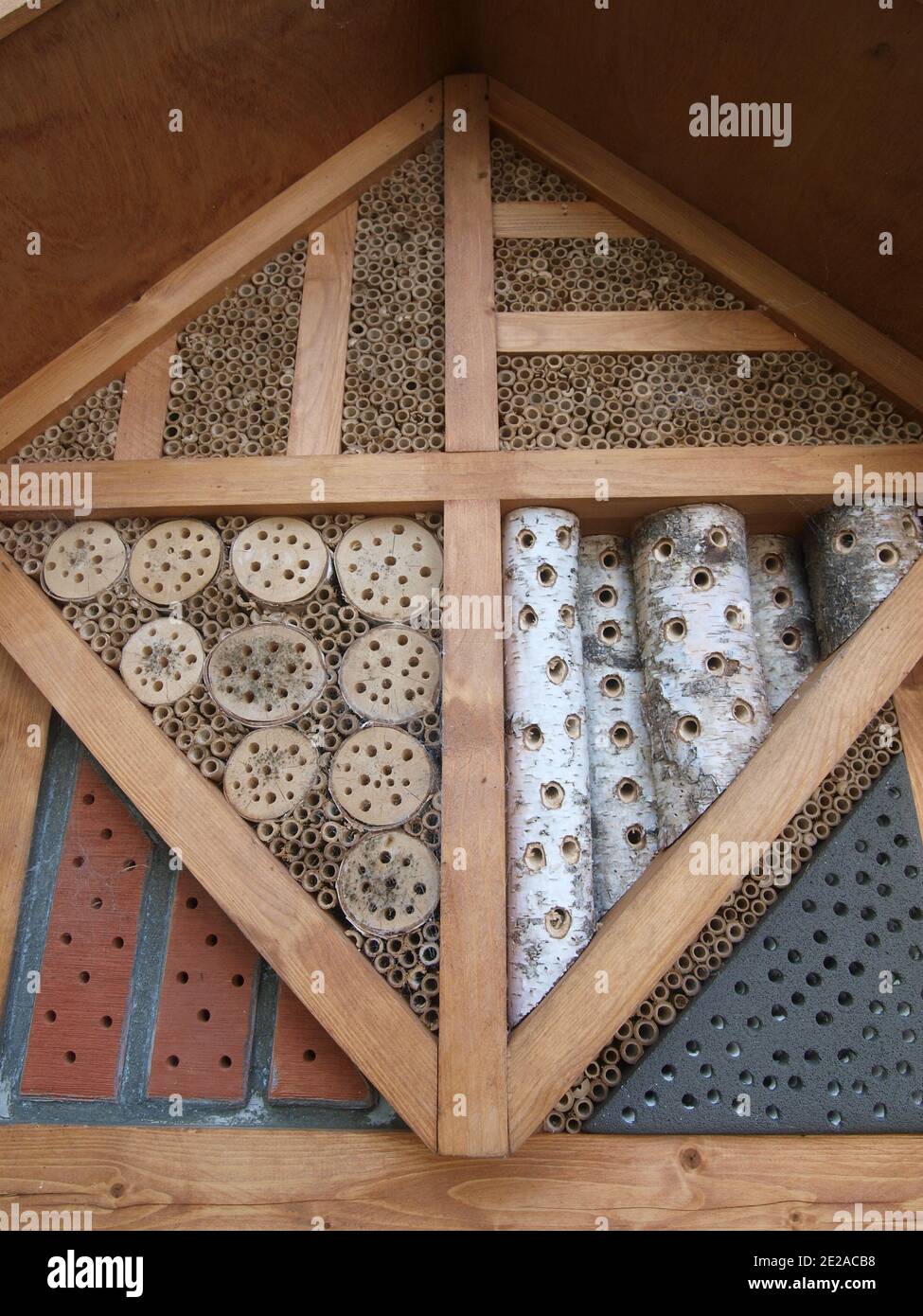 Ein Insektenhotel aus Holz und Naturprodukten in einem Park. Stockfoto