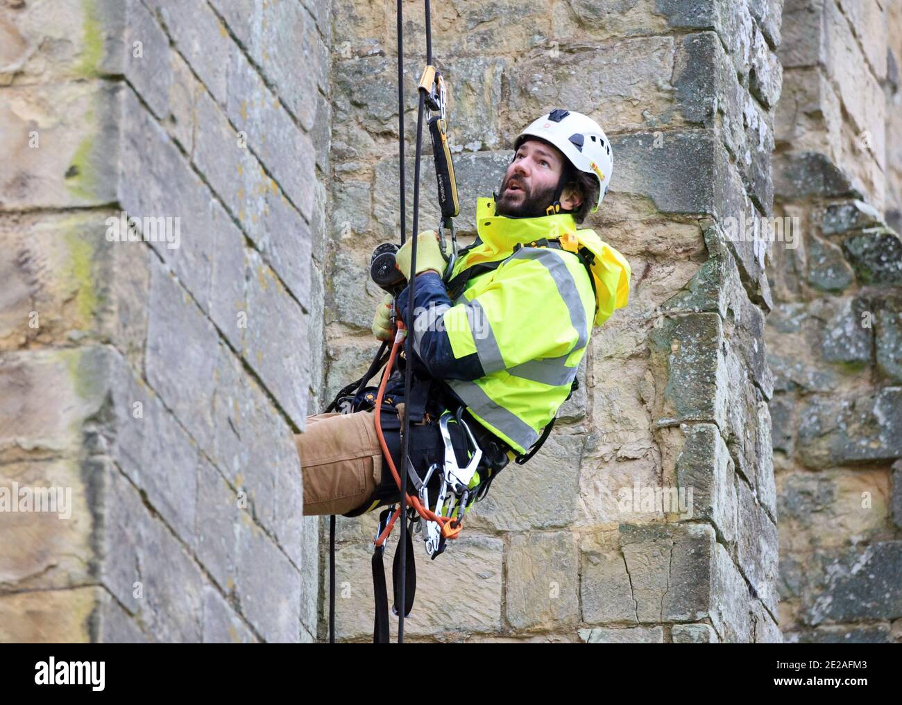 Der Steinmetz James Preston von SSH Conservation, abseils von Rievaulx Abbey in North Yorkshire als English Heritage bereitet sich auf die Durchführung von lebenswichtigen Naturschutzarbeiten vor. English Heritage beauftragt eine Untersuchung der Abtei Rievaulx in einem fünfjährigen Zyklus, um den Zustand der Abtei vom Boden bis zur Spitze der Struktur zu beurteilen. Stockfoto