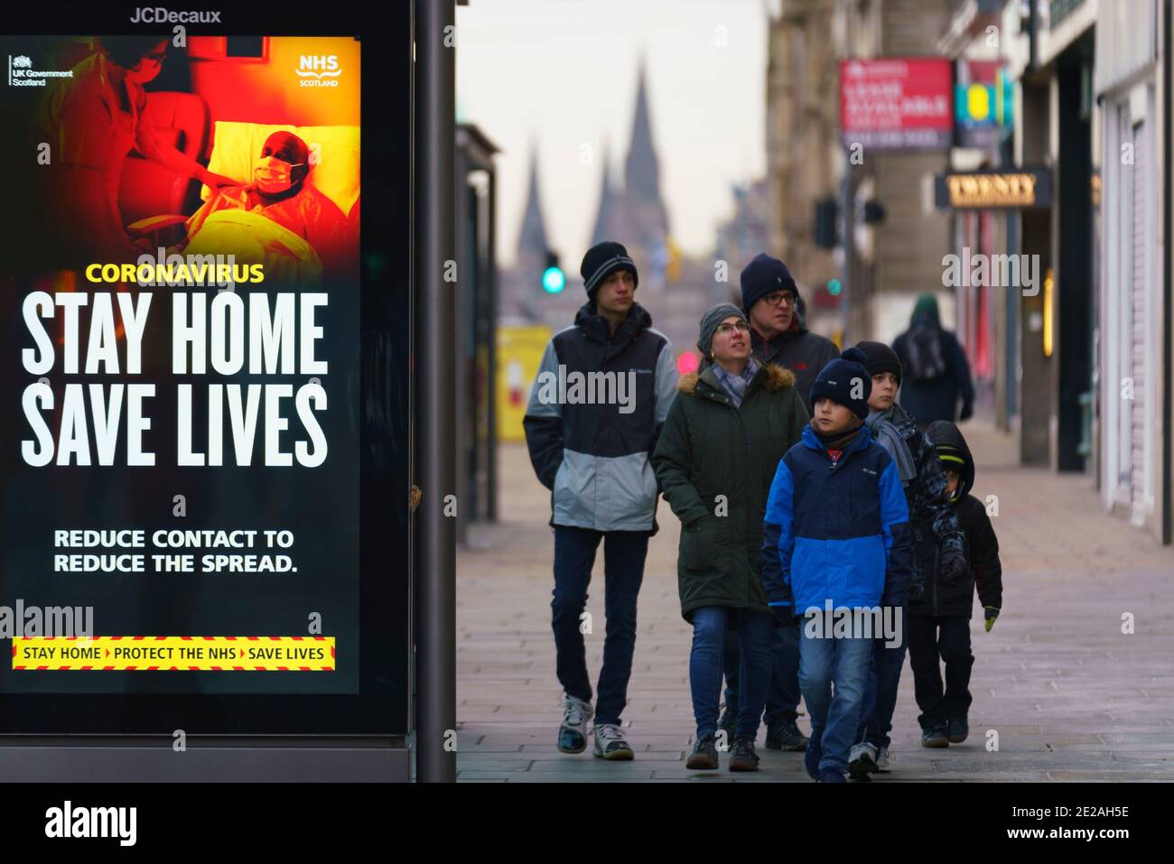 Edinburgh, Schottland, Großbritannien. 13. Januar 2021. Blick auf die praktisch leere Princes Street in Edinburgh mit Gesundheitswarnungen von Covid-19 auf Bushaltestellen. Fast alle Geschäfte haben aufgehört, klicken und sammeln Dienstleistungen so sehr wenige Käufer sind während Lockdown. Iain Masterton/Alamy Live News Stockfoto