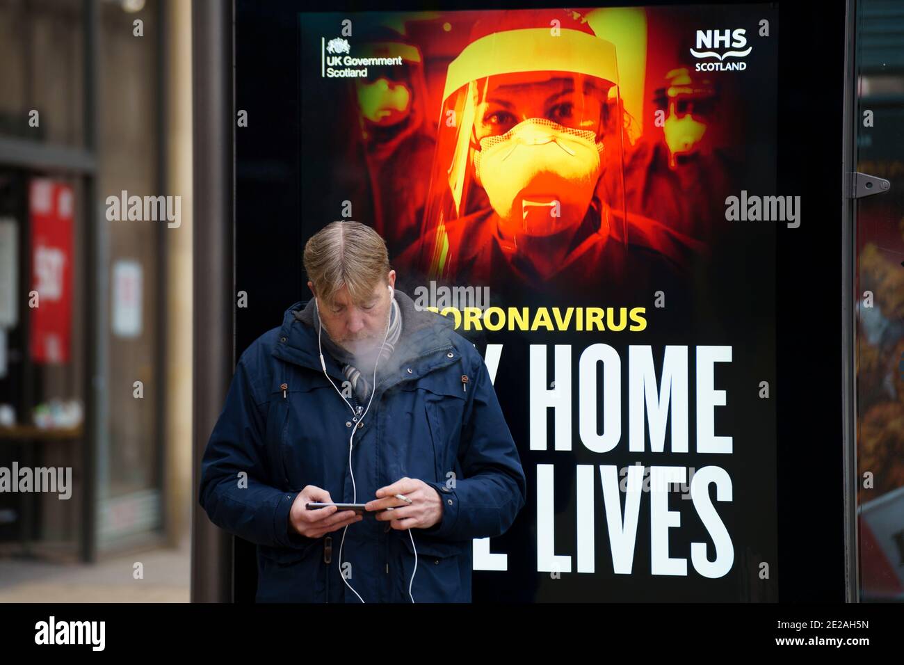 Edinburgh, Schottland, Großbritannien. 13. Januar 2021. Blick auf die praktisch leere Princes Street in Edinburgh mit Gesundheitswarnungen von Covid-19 auf Bushaltestellen. Fast alle Geschäfte haben aufgehört, klicken und sammeln Dienstleistungen so sehr wenige Käufer sind während Lockdown. Iain Masterton/Alamy Live News Stockfoto