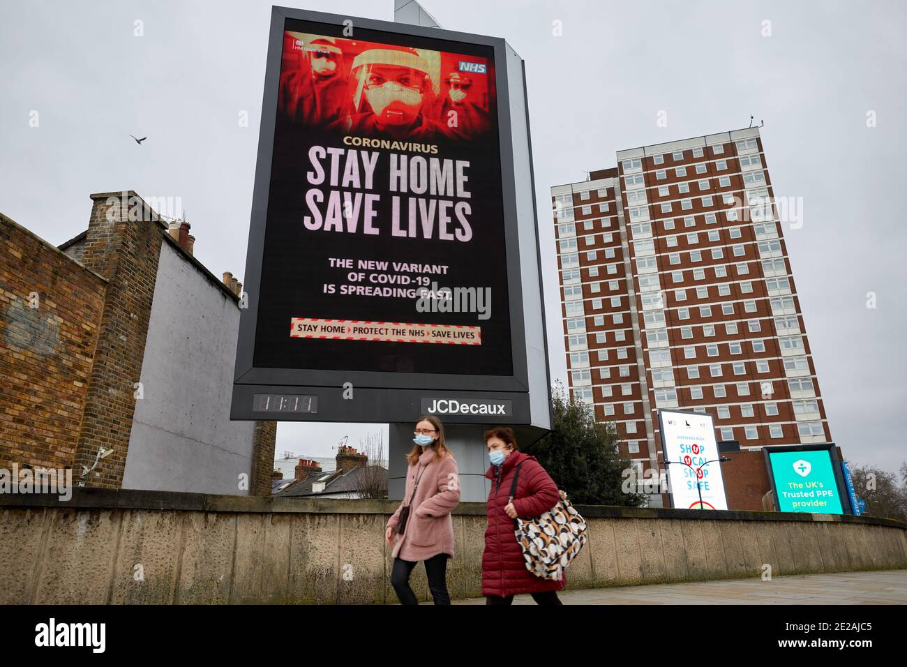 London, Großbritannien. - 11 Jan 2021: Eine große elektronische Plakatwand zeigt eine Regierungsmitteilung an, um während der dritten britischen Coronvirus-Sperre zu Hause zu bleiben. Stockfoto
