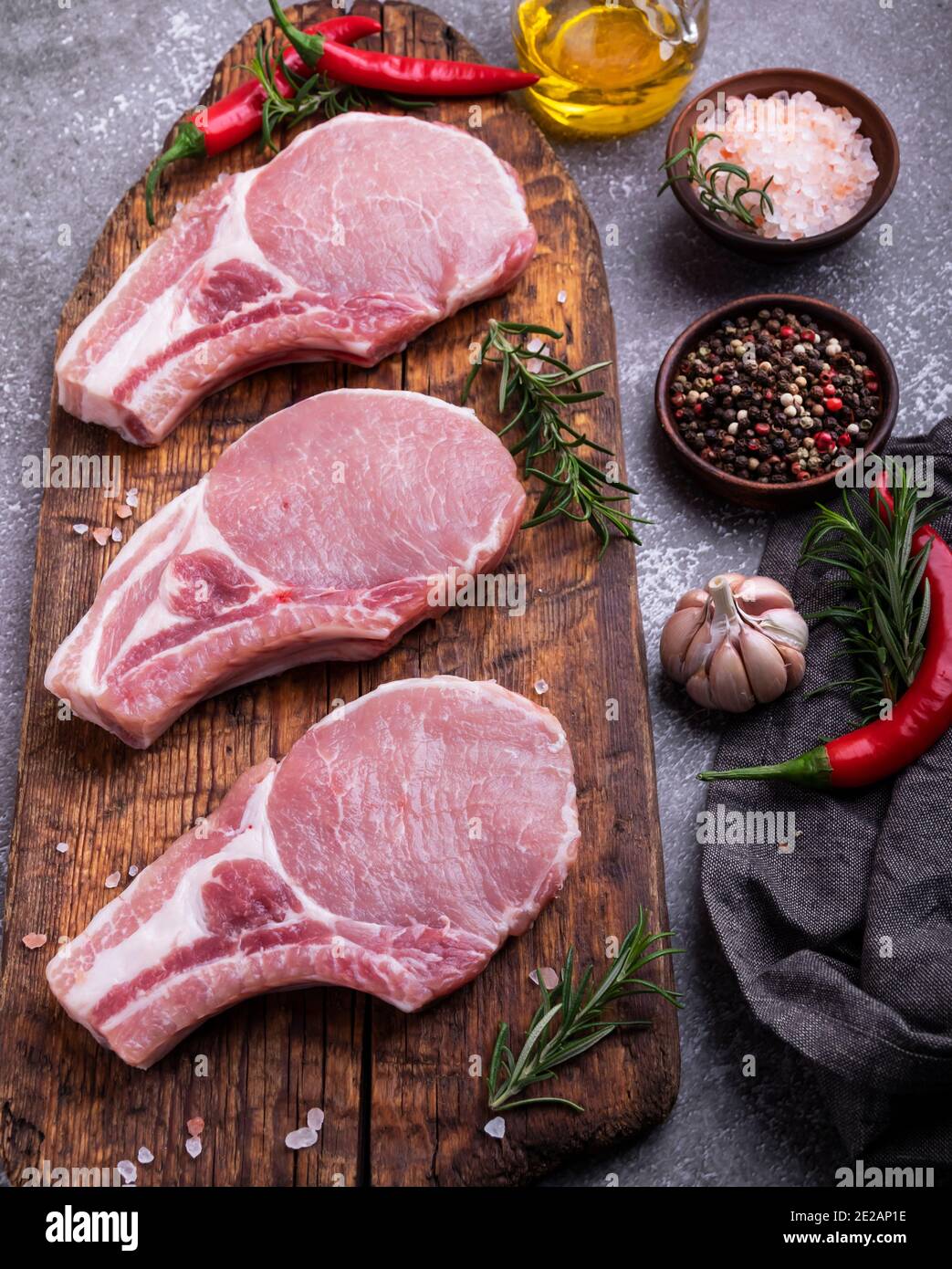 Frische rohe Stücke Fleisch Schweinefleisch, Rindfleisch, Lamm, Hacken auf einem Knochen auf dem Brett, Gewürze Stockfoto