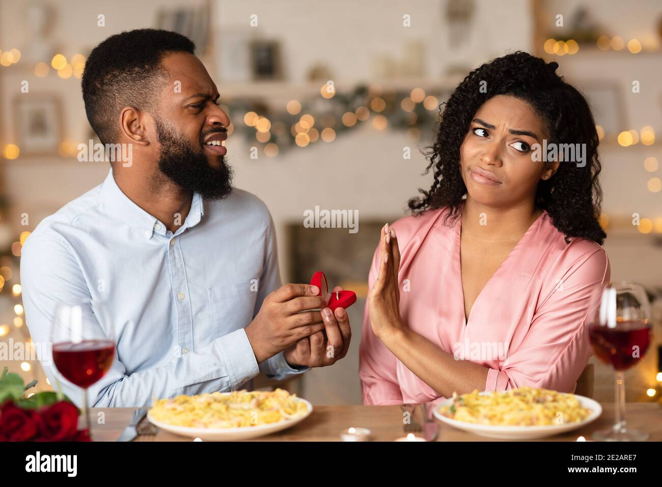 Schwarzer Mann, der Vorschlag mit Ring macht, Frau, die zurückweist Stockfoto